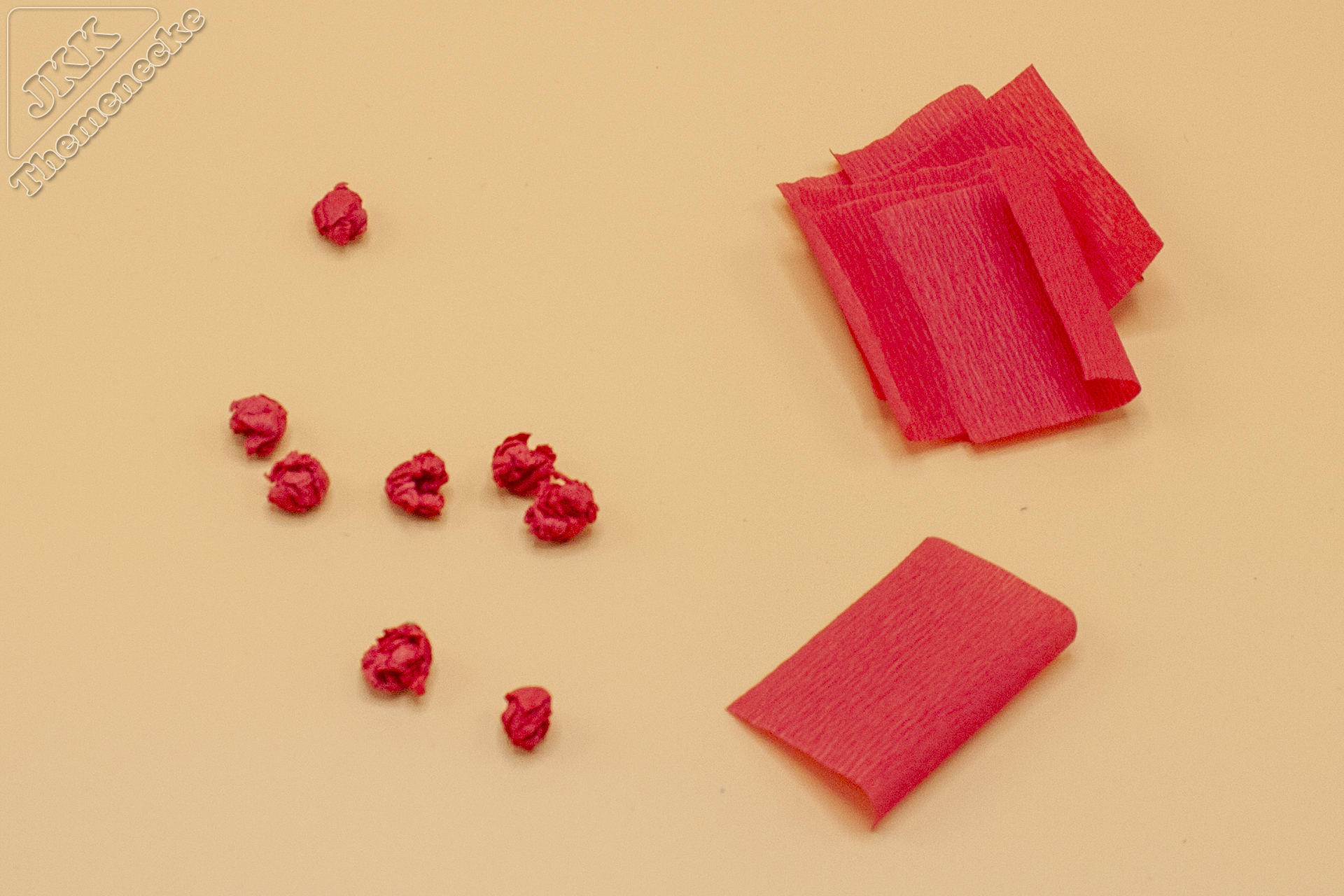 Wir haben uns gemeinsam für rote „Beeren“ entschieden. Das rote Krepppapier wird dafür in Quadrate geschnitten. Und dann durf