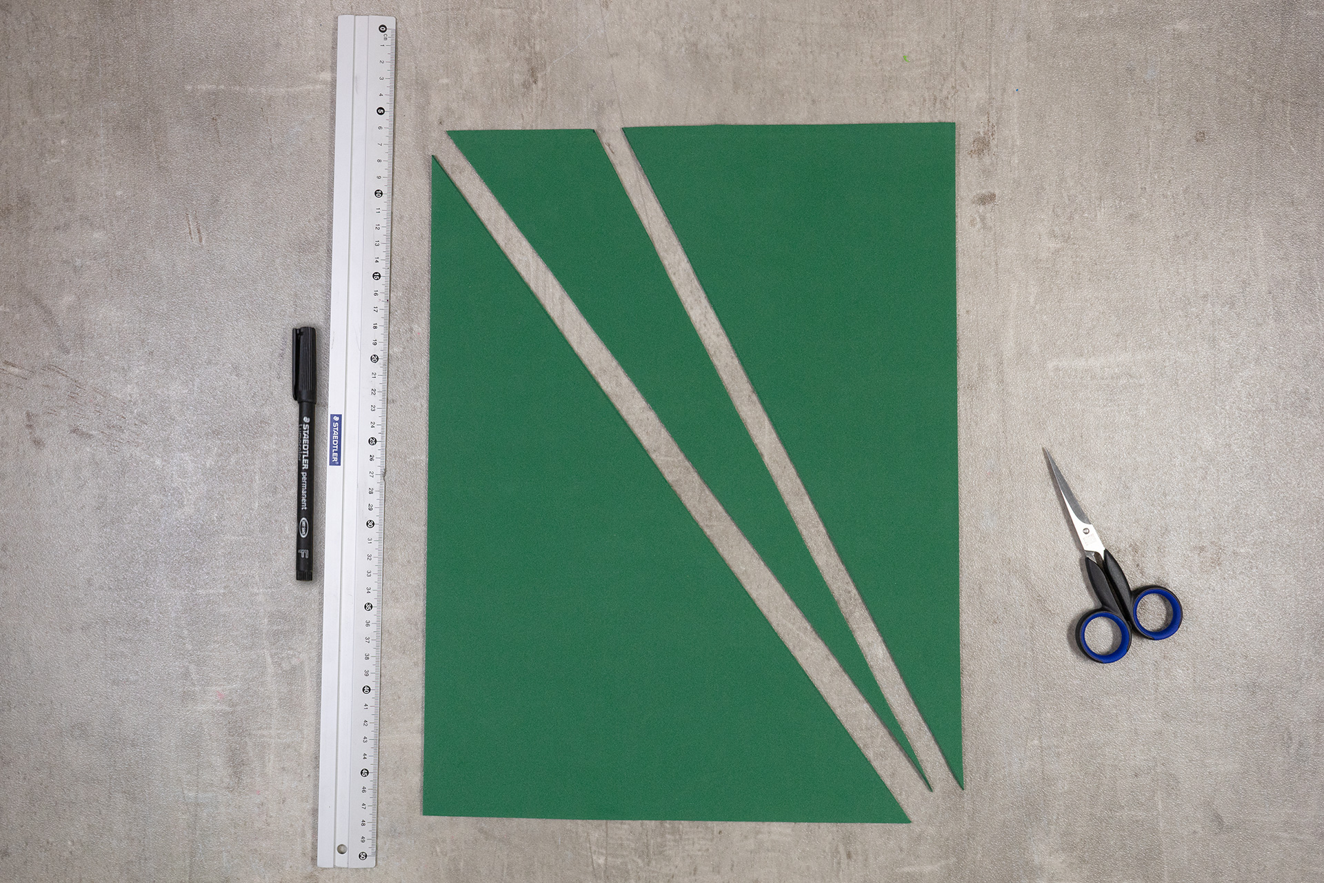 <p>Für den Schwanz markiere ich am kurzen Rand einer tannengrünen Moosgummiplatte von der Ecke aus einen Abstand von 10 cm. D