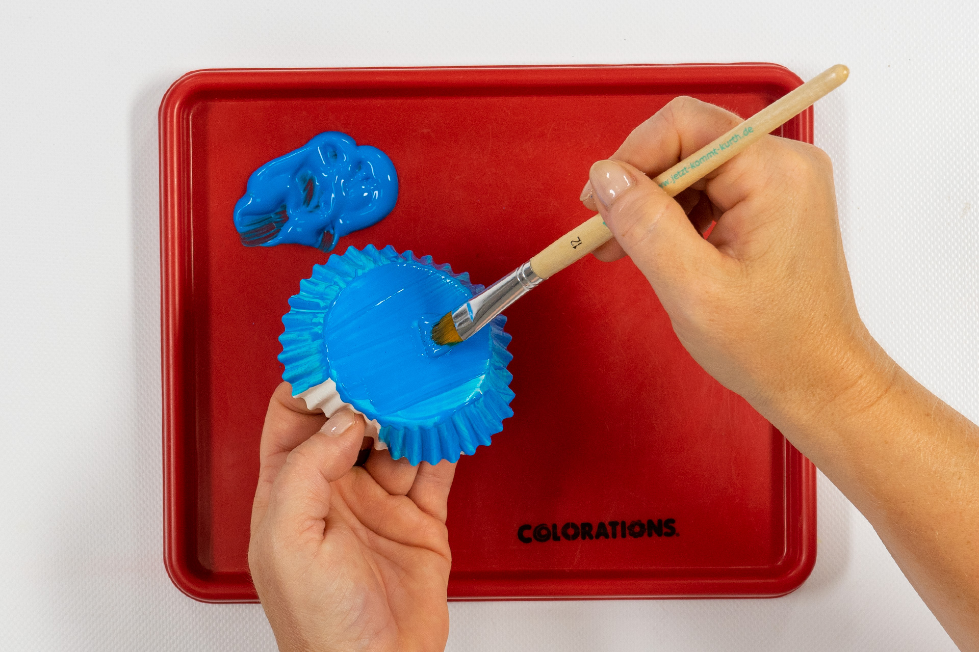 <p>Für den Krakenkörper male ich ein Kuchenförmchen in blauer Basis Color von außen an und lasse es auf dem Kreativtablett tr
